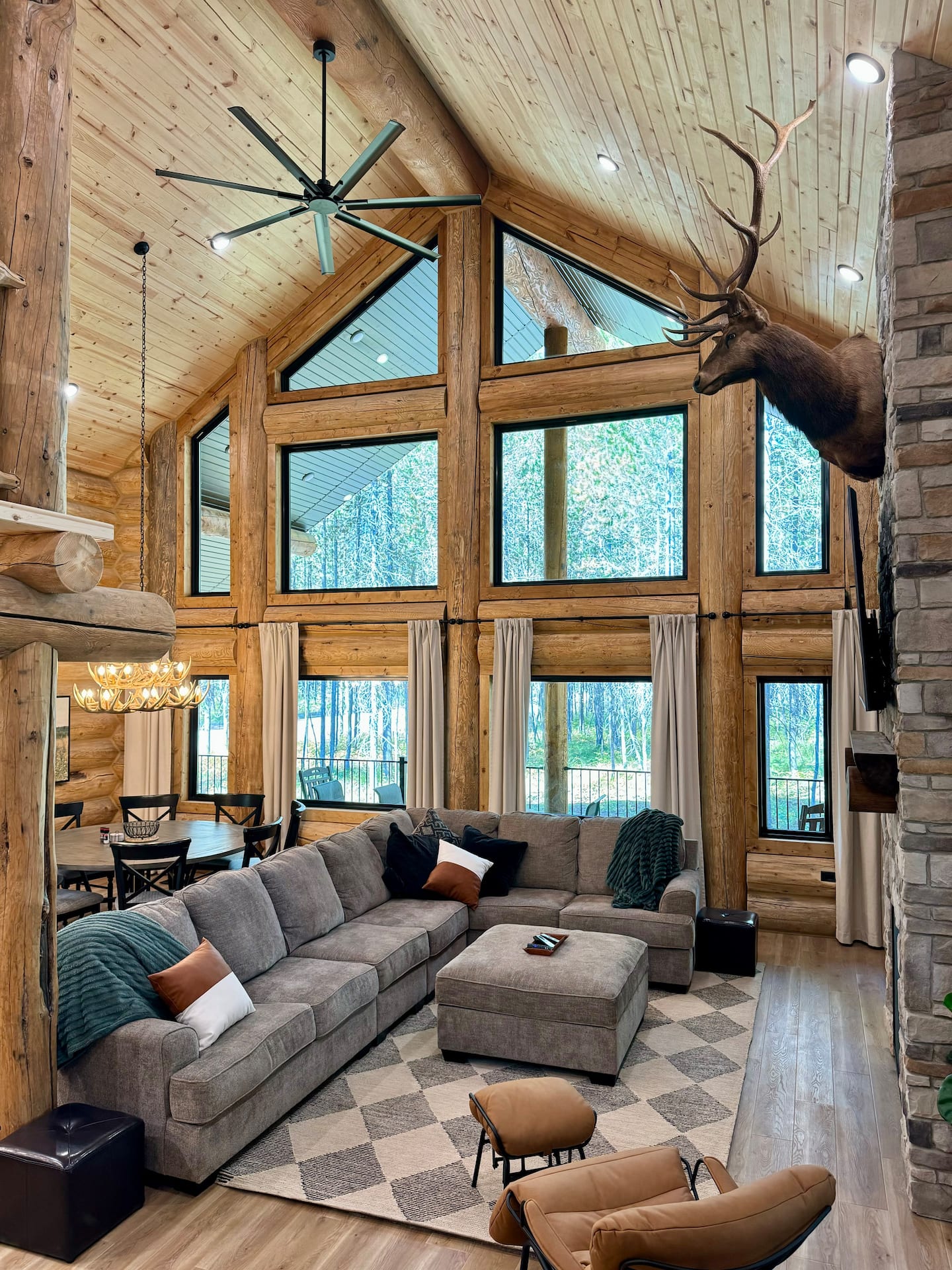 Great room with two-story window wall looking into the forest